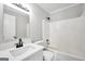 This bathroom is bright and has a shower over tub combo, black faucet and white vanity at 138 Sam Solomon Rd, Locust Grove, GA 30248