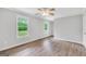 Spacious bedroom with wood-look flooring, neutral paint, ceiling fan, and natural light at 138 Sam Solomon Rd, Locust Grove, GA 30248