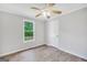 This is a light and airy bedroom with a ceiling fan, wood-look floors and a large window at 138 Sam Solomon Rd, Locust Grove, GA 30248