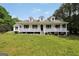 Inviting white home boasts a covered porch and well-maintained front yard at 138 Sam Solomon Rd, Locust Grove, GA 30248
