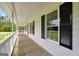 Inviting covered porch with white railings and black shuttered windows at 138 Sam Solomon Rd, Locust Grove, GA 30248