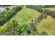 Stunning aerial view of a home surrounded by lush greenery and a large, open field at 614 Highway 85 Conn, Brooks, GA 30205