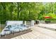 Back deck with a hot tub, grill, and outdoor dining set, all surrounded by lush greenery at 614 Highway 85 Conn, Brooks, GA 30205