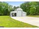 Spacious white barn featuring three garage doors and a separate area for a workspace or storage at 614 Highway 85 Conn, Brooks, GA 30205