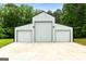 White barn featuring three garage doors, offering ample storage space and a modern design in a rural setting at 614 Highway 85 Conn, Brooks, GA 30205