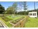 Fenced garden featuring raised beds, lush greenery, and a charming shed in the background at 614 Highway 85 Conn, Brooks, GA 30205