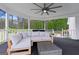 Covered porch with a comfortable sectional sofa, ceiling fan, and wooded backyard views at 614 Highway 85 Conn, Brooks, GA 30205