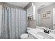 Cozy bathroom featuring a shower with a patterned curtain, white vanity, and a mirrored medicine cabinet at 103 Manx Dr, Grantville, GA 30220