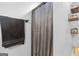 Bathroom shower with silver curtain, decorative floating shelves, and neutral paint at 103 Manx Dr, Grantville, GA 30220