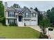 Charming two-story home with solar panels, green lawn, and a two car garage at 103 Manx Dr, Grantville, GA 30220