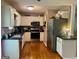 Well-equipped kitchen with white cabinets, stainless steel appliances, and hardwood floors at 103 Manx Dr, Grantville, GA 30220