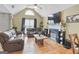Cozy living room featuring hardwood floors, a fireplace, and vaulted ceiling, with a fan at 103 Manx Dr, Grantville, GA 30220