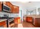 Bright kitchen features stainless steel appliances, dark wooden cabinets, hardwood floors, and a modern range at 3313 Bethesda Ter, Acworth, GA 30101