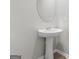Elegant powder room featuring pedestal sink and decorative mirror at 8069 Louis Dr, Locust Grove, GA 30248