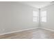 Bright bedroom with two windows dressed with white blinds and wood-look flooring at 8069 Louis Dr, Locust Grove, GA 30248