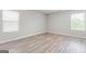 Bright bedroom with two windows and stylish light-colored wood flooring at 8069 Louis Dr, Locust Grove, GA 30248