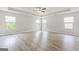 Spacious bedroom with tray ceiling, three windows, and light-colored wood flooring at 8069 Louis Dr, Locust Grove, GA 30248