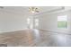 Spacious bedroom with tray ceiling, light-colored wood flooring, and an attached bathroom at 8069 Louis Dr, Locust Grove, GA 30248