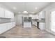 Bright, open kitchen features white cabinetry, stainless steel appliances, granite counters, and wood-look floors at 8069 Louis Dr, Locust Grove, GA 30248