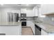 Kitchen with white cabinets, stainless steel appliances, granite counters, and wood-look floors at 8069 Louis Dr, Locust Grove, GA 30248