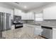 Kitchen with white cabinets, stainless steel appliances, granite counters, backsplash and wood-look floors at 8069 Louis Dr, Locust Grove, GA 30248
