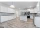 Spacious kitchen featuring white cabinets, stainless steel appliances, a kitchen island, and wood-look floors at 8069 Louis Dr, Locust Grove, GA 30248