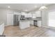 Bright kitchen with white cabinets, stainless steel appliances, a center island, and wood-look flooring at 8069 Louis Dr, Locust Grove, GA 30248