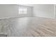 Spacious living room featuring wood-look flooring, large window, and neutral-toned walls at 8069 Louis Dr, Locust Grove, GA 30248
