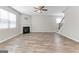 Bright living room featuring a cozy fireplace, staircase, and wood-look floors, perfect for entertaining or relaxing at 8069 Louis Dr, Locust Grove, GA 30248