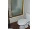 Bathroom features a white commode and bathtub with sliding glass door at 1023 Falling Water Se Dr, Smyrna, GA 30080