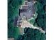 An aerial view of a home featuring multiple windows and dark roofing surrounded by a dense tree line at 145 E Lake Dr, Mountain Park, GA 30075