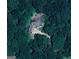 Aerial view of a home surrounded by greenery with a long driveway winding through lush trees at 145 E Lake Dr, Mountain Park, GA 30075