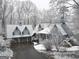 Winter scene of a charming home nestled among snow-covered trees with a private driveway at 145 E Lake Dr, Mountain Park, GA 30075