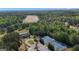 Aerial view of luxury home, tennis courts, pool, and lake surrounded by lush trees in a beautiful community at 335 Discovery Lake Dr, Fayetteville, GA 30215