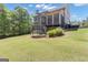 Large, grassy backyard featuring a trampoline and mature landscaping, offering a private outdoor space at 335 Discovery Lake Dr, Fayetteville, GA 30215