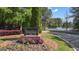 Welcoming entrance sign to The Lake Club with beautifully landscaped flower bed and view of tennis courts at 335 Discovery Lake Dr, Fayetteville, GA 30215
