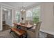 Dining room with a rustic wood table, bench seating, modern lighting, and bright natural light at 335 Discovery Lake Dr, Fayetteville, GA 30215