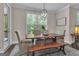 Bright dining room featuring natural lighting, elegant chandelier, and rustic wood table with seating at 335 Discovery Lake Dr, Fayetteville, GA 30215