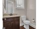 Chic half bath with dark wood vanity, granite countertop, modern faucet, and white toilet at 335 Discovery Lake Dr, Fayetteville, GA 30215