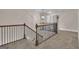 Upper hallway with iron railing and a decorative light fixture, offering a view of the lower level at 335 Discovery Lake Dr, Fayetteville, GA 30215