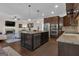 Open kitchen featuring a center island, dark cabinets, and stainless appliances adjacent to the living area at 335 Discovery Lake Dr, Fayetteville, GA 30215