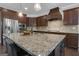 Open-concept kitchen featuring dark wood cabinetry, granite countertops, and a center island with sink at 335 Discovery Lake Dr, Fayetteville, GA 30215