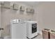Laundry room with front load washer and dryer on tiled floor with storage shelving at 335 Discovery Lake Dr, Fayetteville, GA 30215
