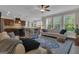 Open-concept living room featuring hardwood floors, a ceiling fan, and natural light from large windows at 335 Discovery Lake Dr, Fayetteville, GA 30215