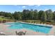 Large pool with chairs and tables surrounded by lush trees offering a relaxing outdoor experience at 335 Discovery Lake Dr, Fayetteville, GA 30215