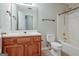 Traditional bathroom design featuring a wooden vanity, neutral walls, tile floor, and a shower-tub combo at 250 Kari Glen Dr, Fayetteville, GA 30215