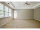 Bright bedroom featuring neutral walls, carpet floor, tray ceiling, ceiling fan, and a large window at 250 Kari Glen Dr, Fayetteville, GA 30215