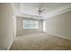 Bright bedroom featuring neutral walls, carpet floor, tray ceiling, ceiling fan, and a back door at 250 Kari Glen Dr, Fayetteville, GA 30215