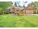 Charming single-story brick home featuring an attached garage, a well-manicured lawn and mature trees at 250 Kari Glen Dr, Fayetteville, GA 30215