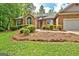 Charming single-story brick home featuring an attached garage, mature trees and a well-manicured lawn at 250 Kari Glen Dr, Fayetteville, GA 30215